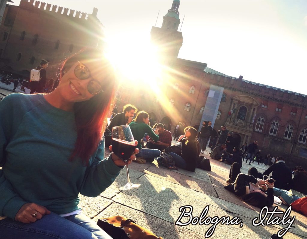 Enjoy a glass of wine in front of the Palazzo d'Accursio in Bologna!