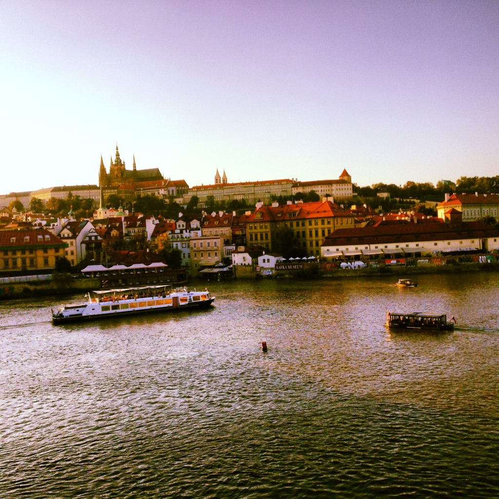 A view of Prague castle and the river at sunset