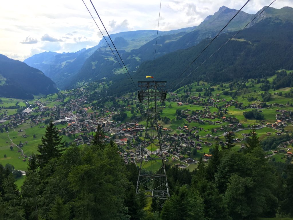 Views of the mountains, trees, and the city of Grindelwald from the Luftseilbahn Grindelwald Pfingstegg