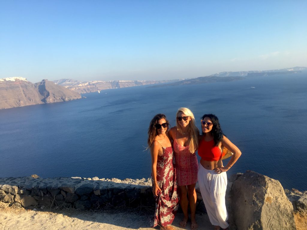 Girls posing on the cliffs of Santorini